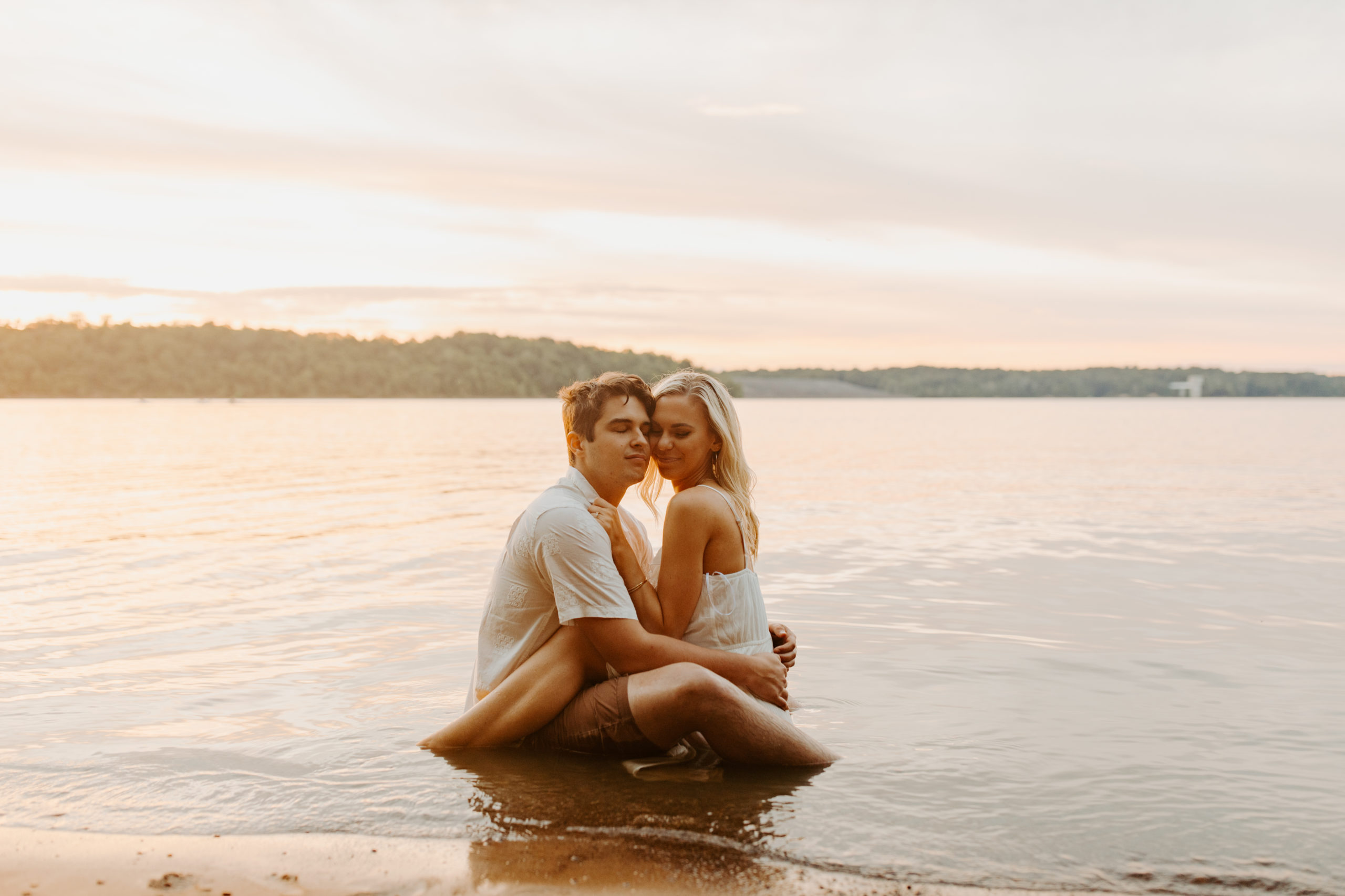 couple sitting in water for engagement photography session