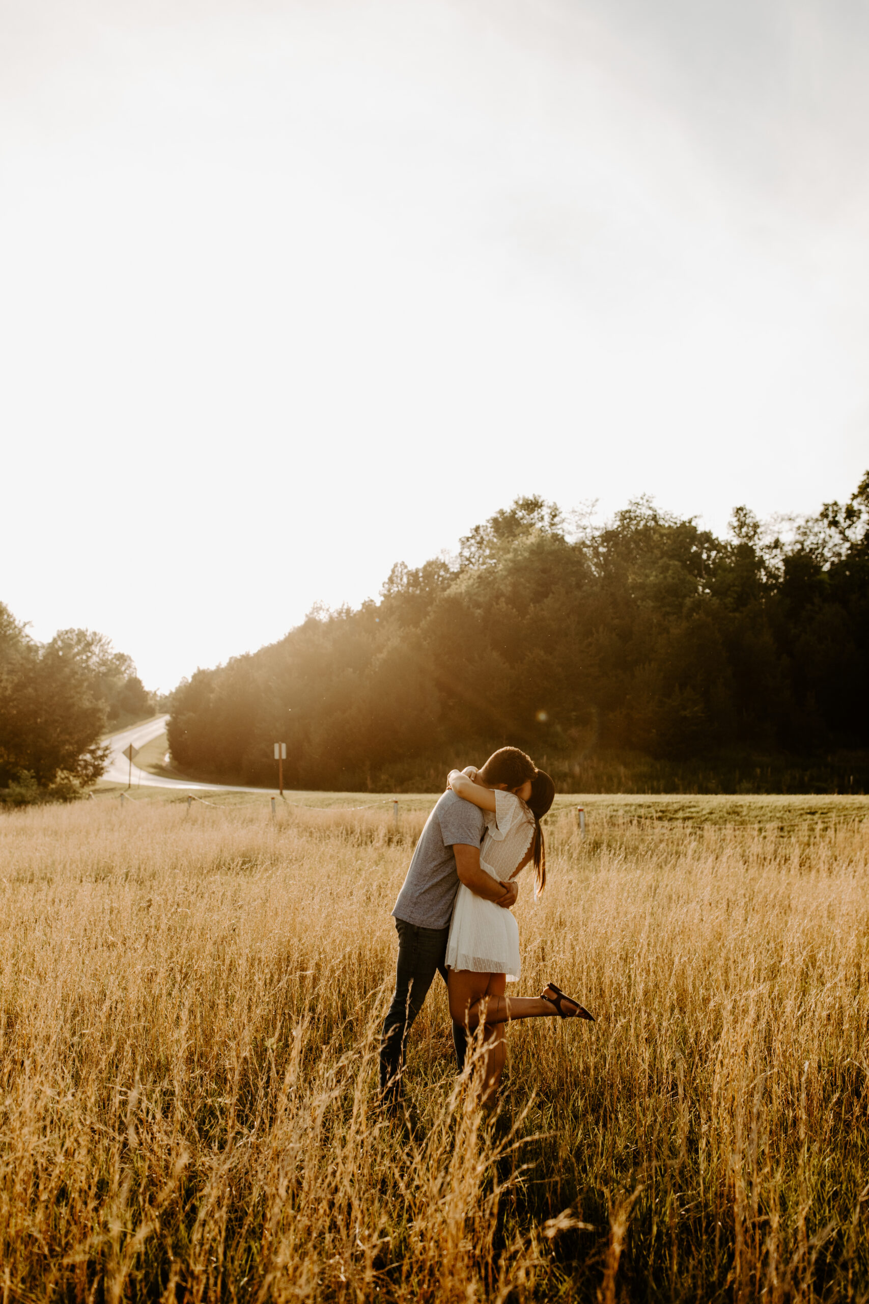 Couples' Engagement photos in an open field during golden hour.