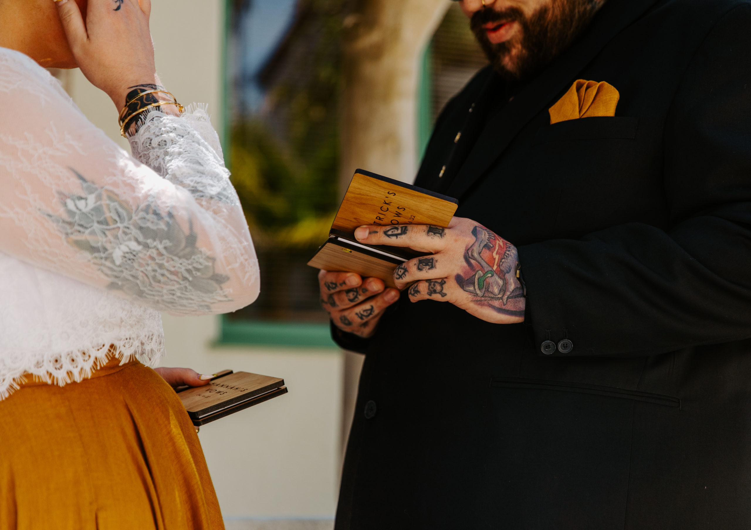 groom holding a custom engraved vow book reading his wedding vows in Ocean Beach San Diego 