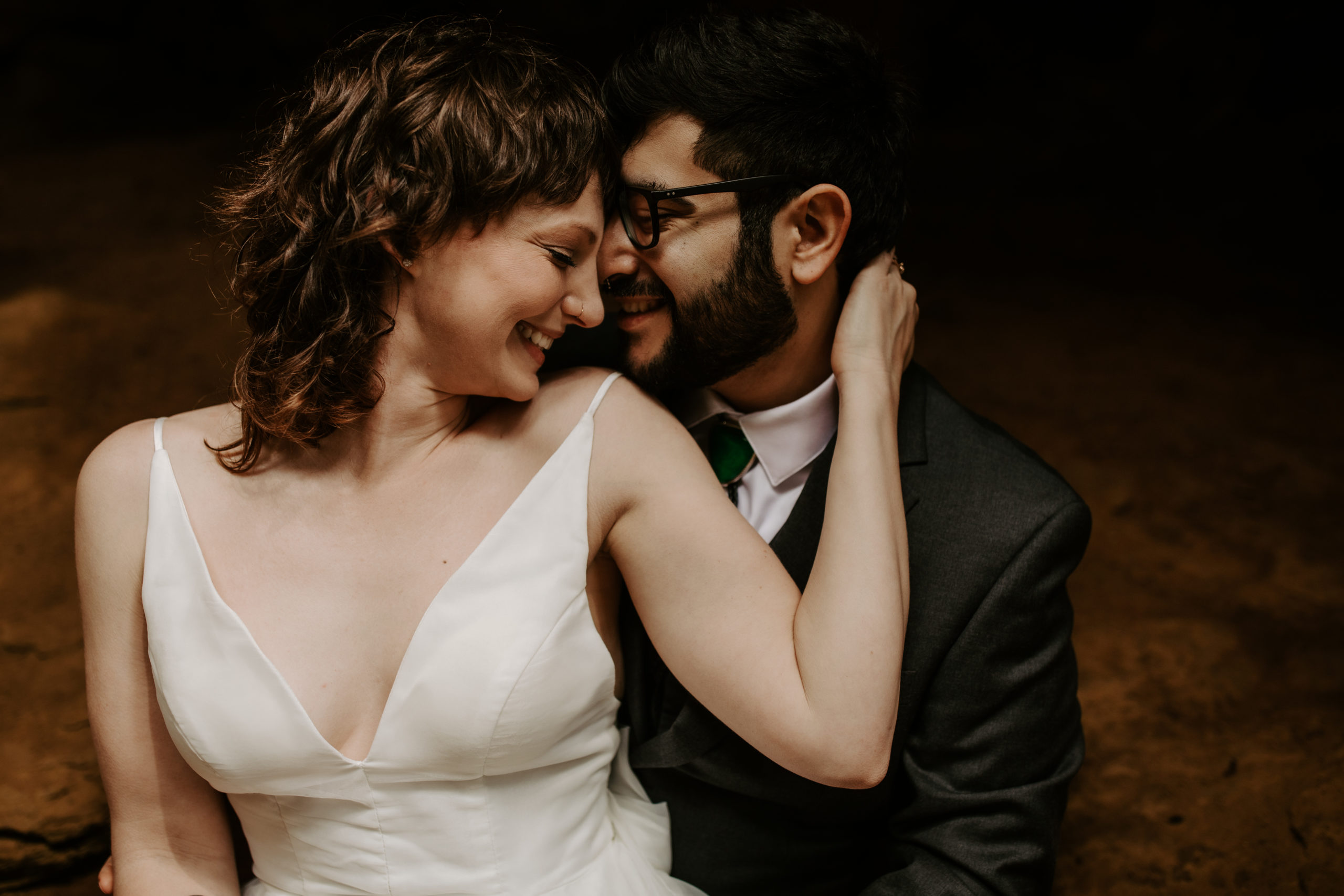 a couple at their hocking hills elopement smiling/laughing by Conkle's Hollow Waterfall