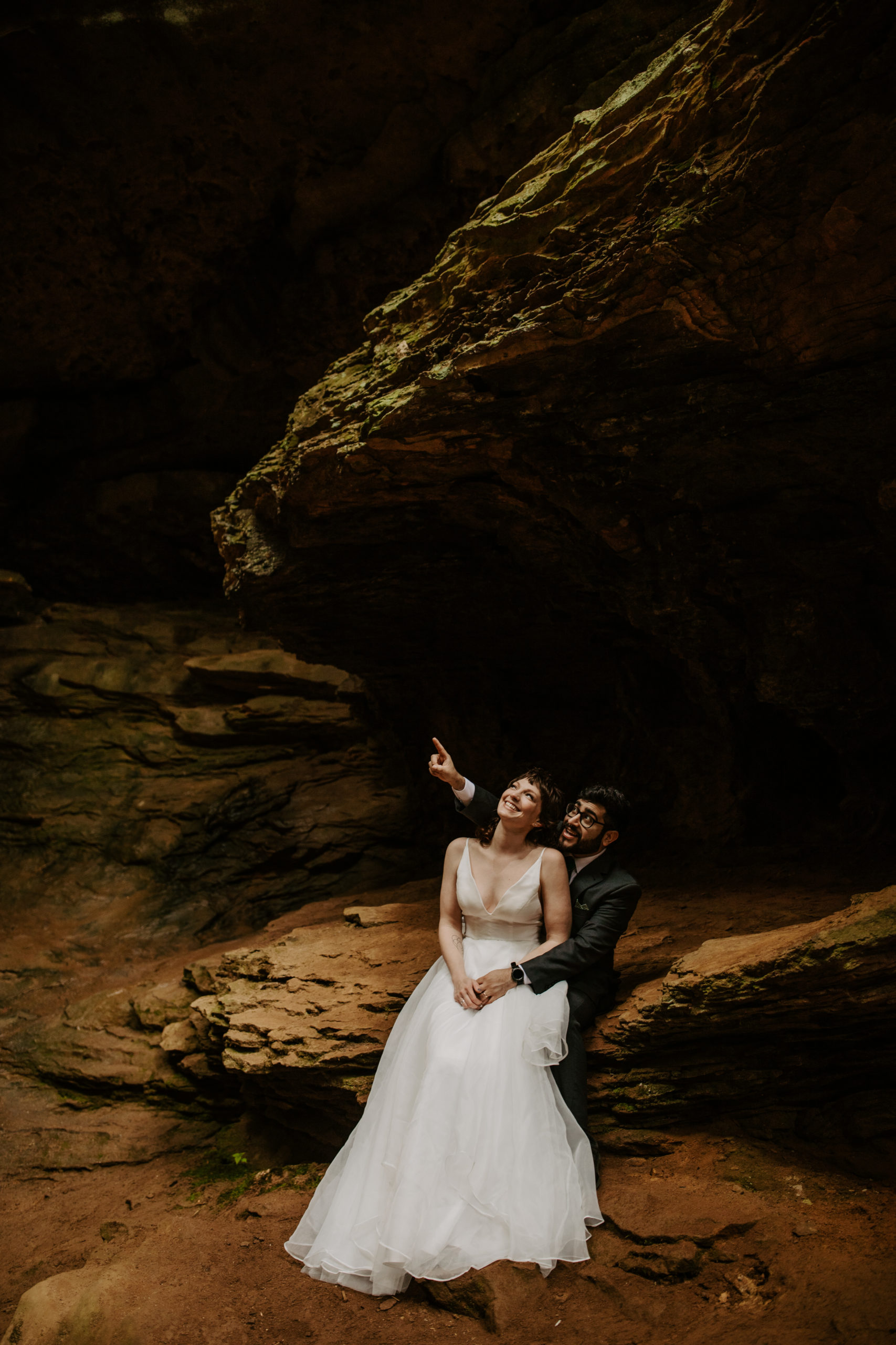 Eloping Couple Stting on Limestone Rocks at the Conkles hollow Trail at hocking Hills Ohio