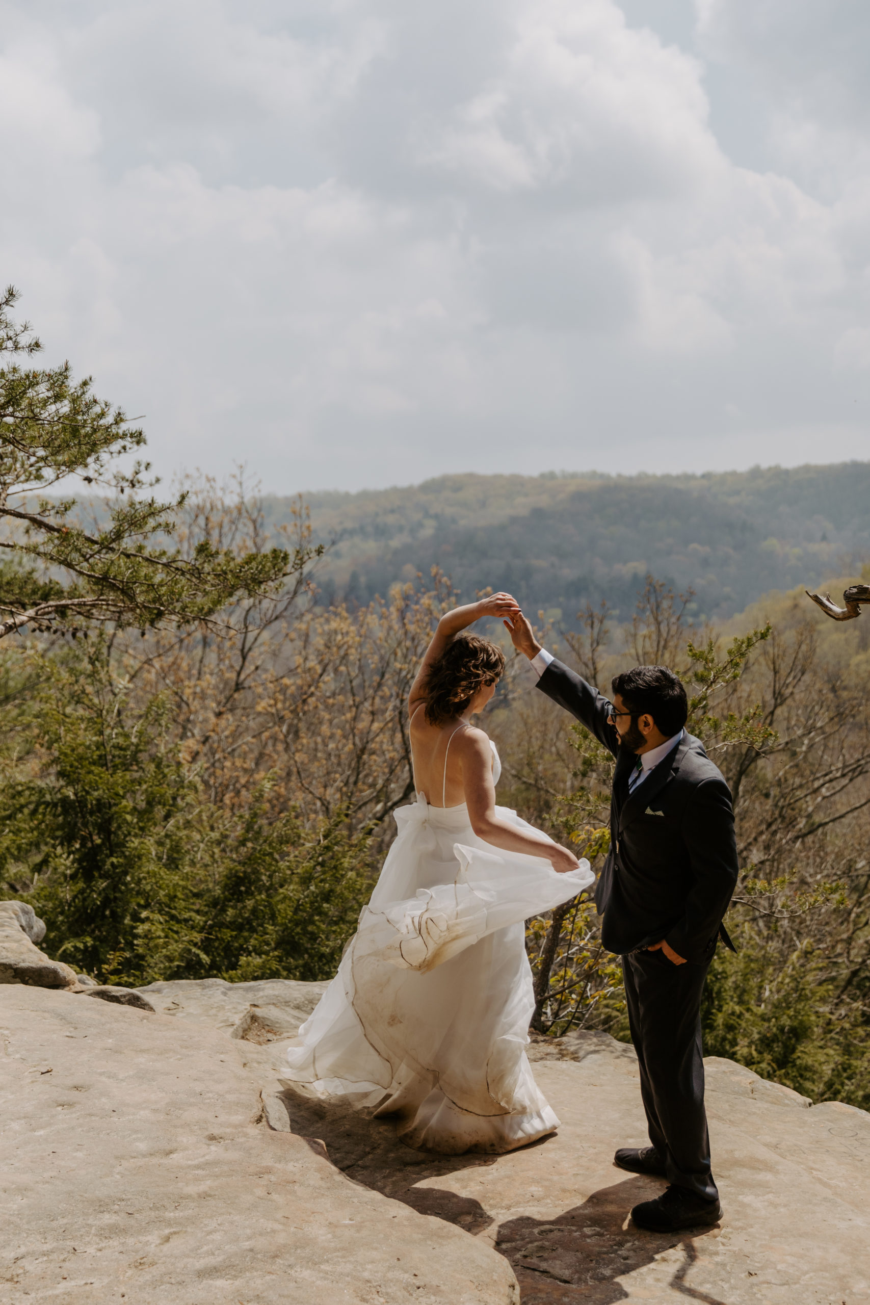 eloping couple dancing on cliff edge at Conkle's Hollow