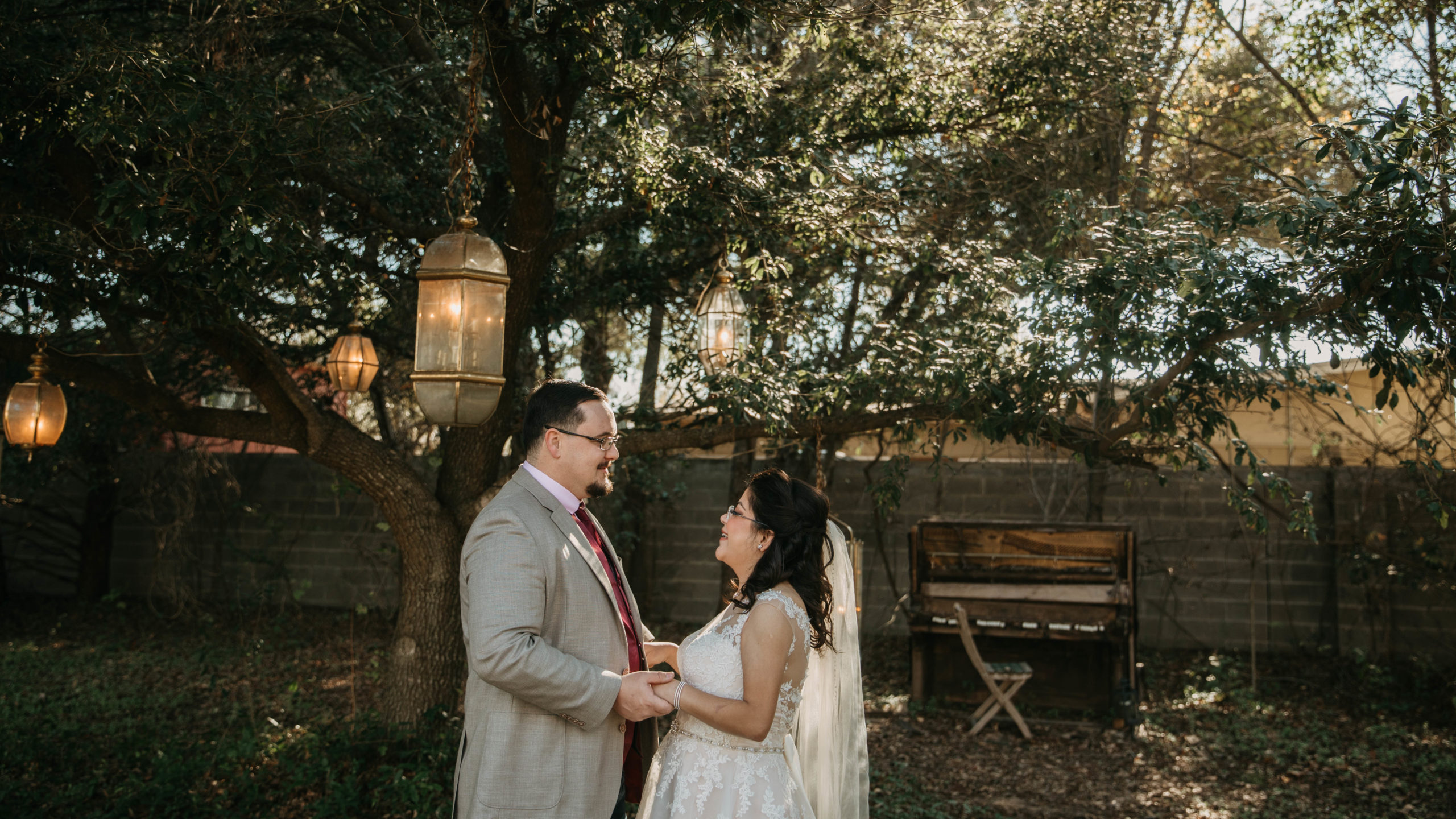 A photo of an eloping couples at the Sekrit Theater in Austin, Texas. The couple is standing under a chandelier tree during sunset.