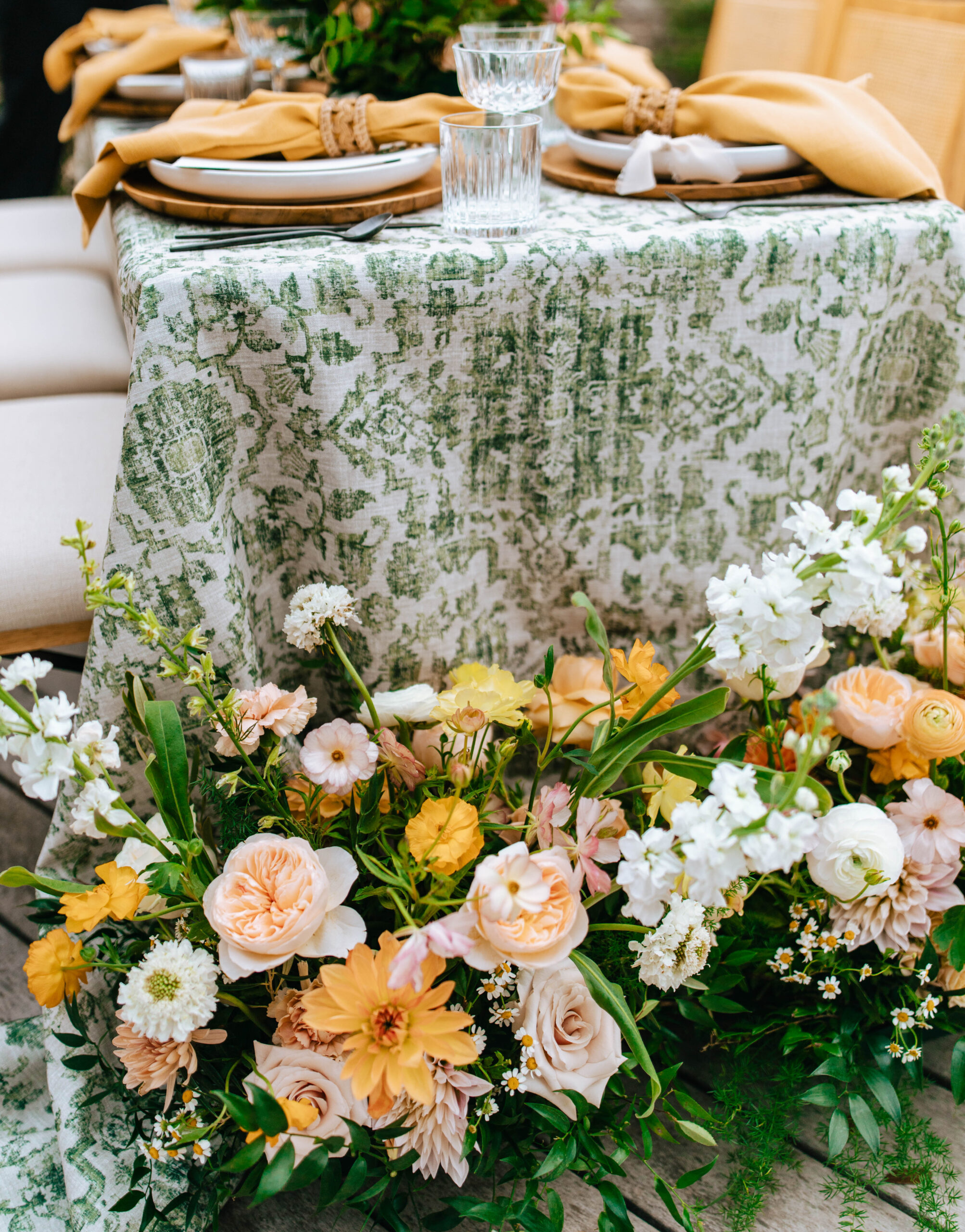 A photograph of Austin Spring Wedding Florals by Hippie Hippie Florals, Photo by Bare Moments Photography. Features a table centerpiece made of yellow wildflowers, peach peonies, and more assorted colorful flowers. 