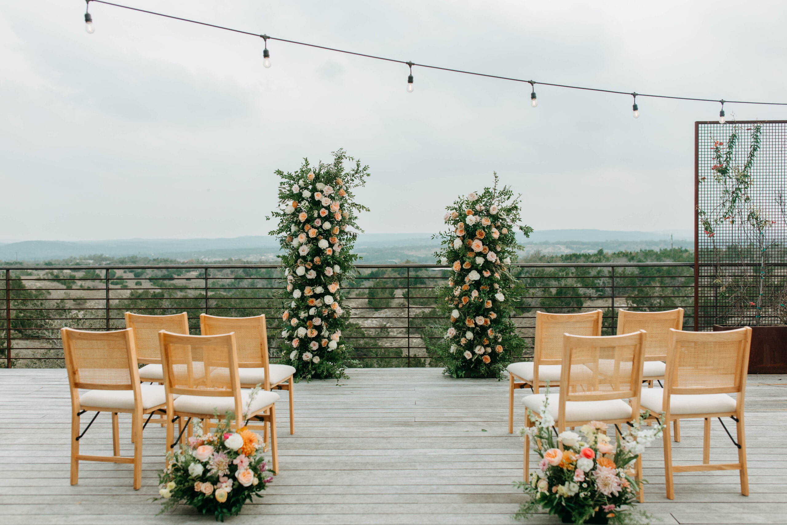 Ceremony Floral Arch set up overlooking the rolling hills of Texas hill Country. Taken at the Cactus Moon Lodge Wedding Venue in Austin Texas. 