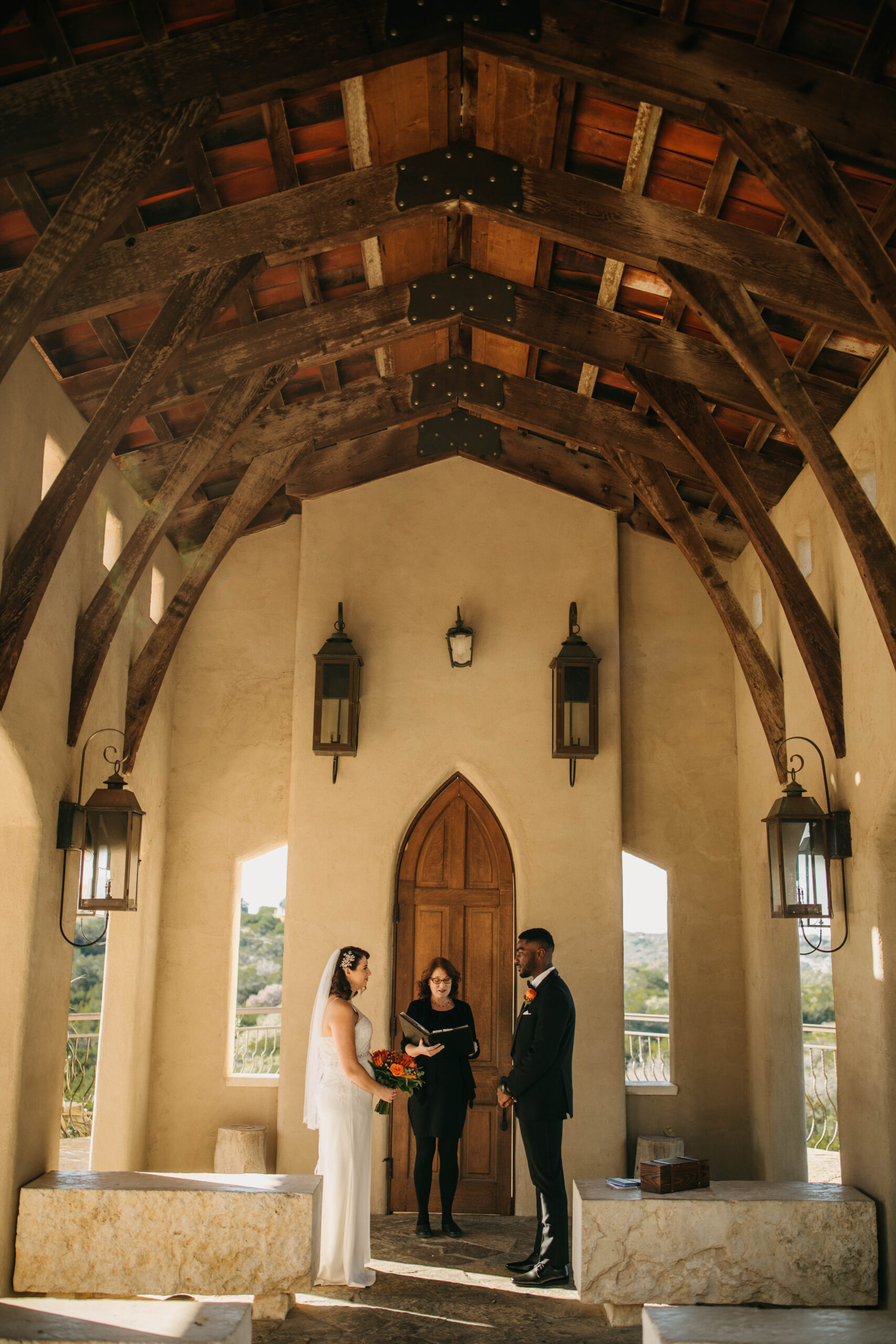 A photograph of a wedding ceremony in Austin Texas. A couple is reading their vows at Chapel Dulcinea. 