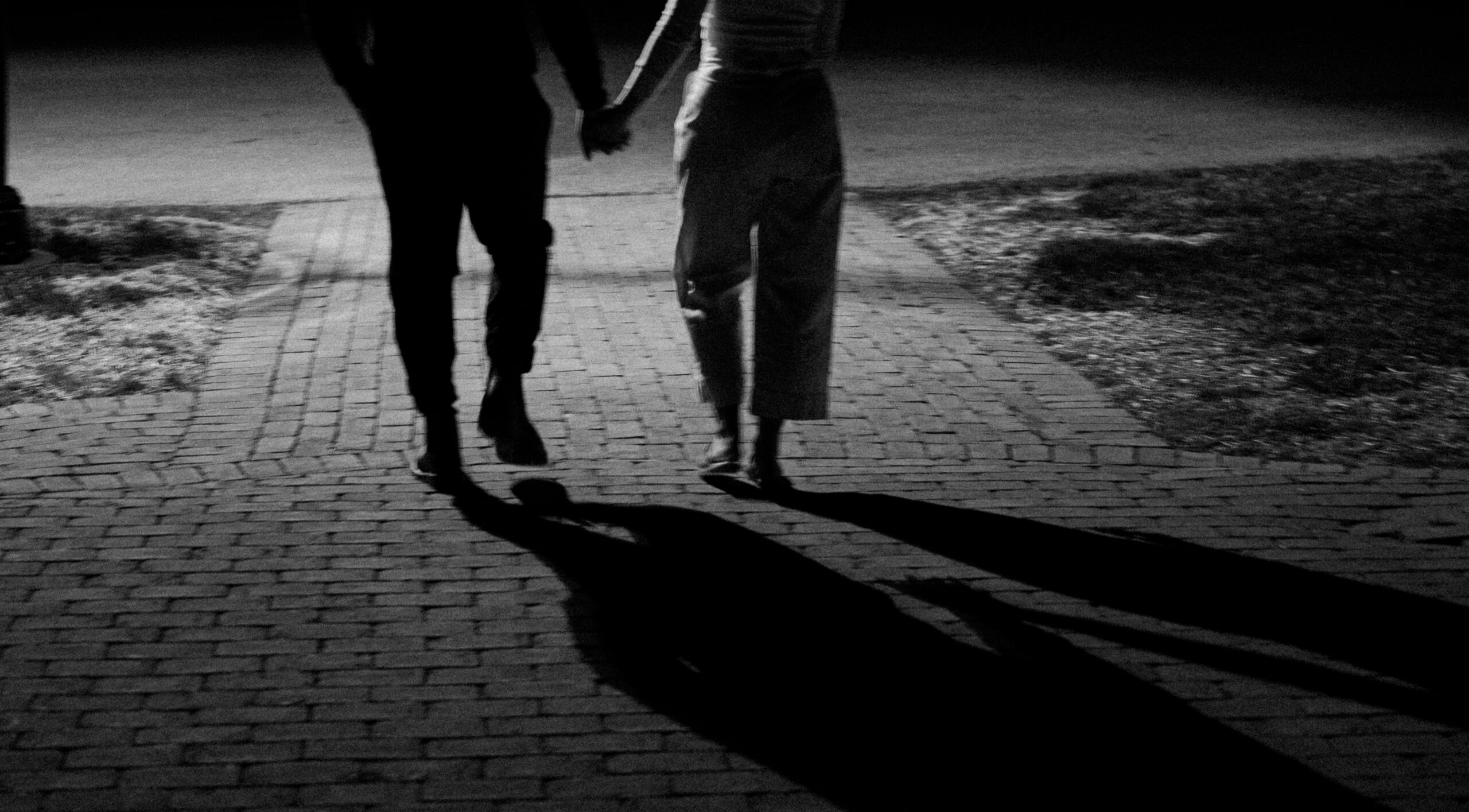 Night-time walking photo in black and white of an engaged couple at their Engagement Session. Session location is the Cincinnati Observatory. 