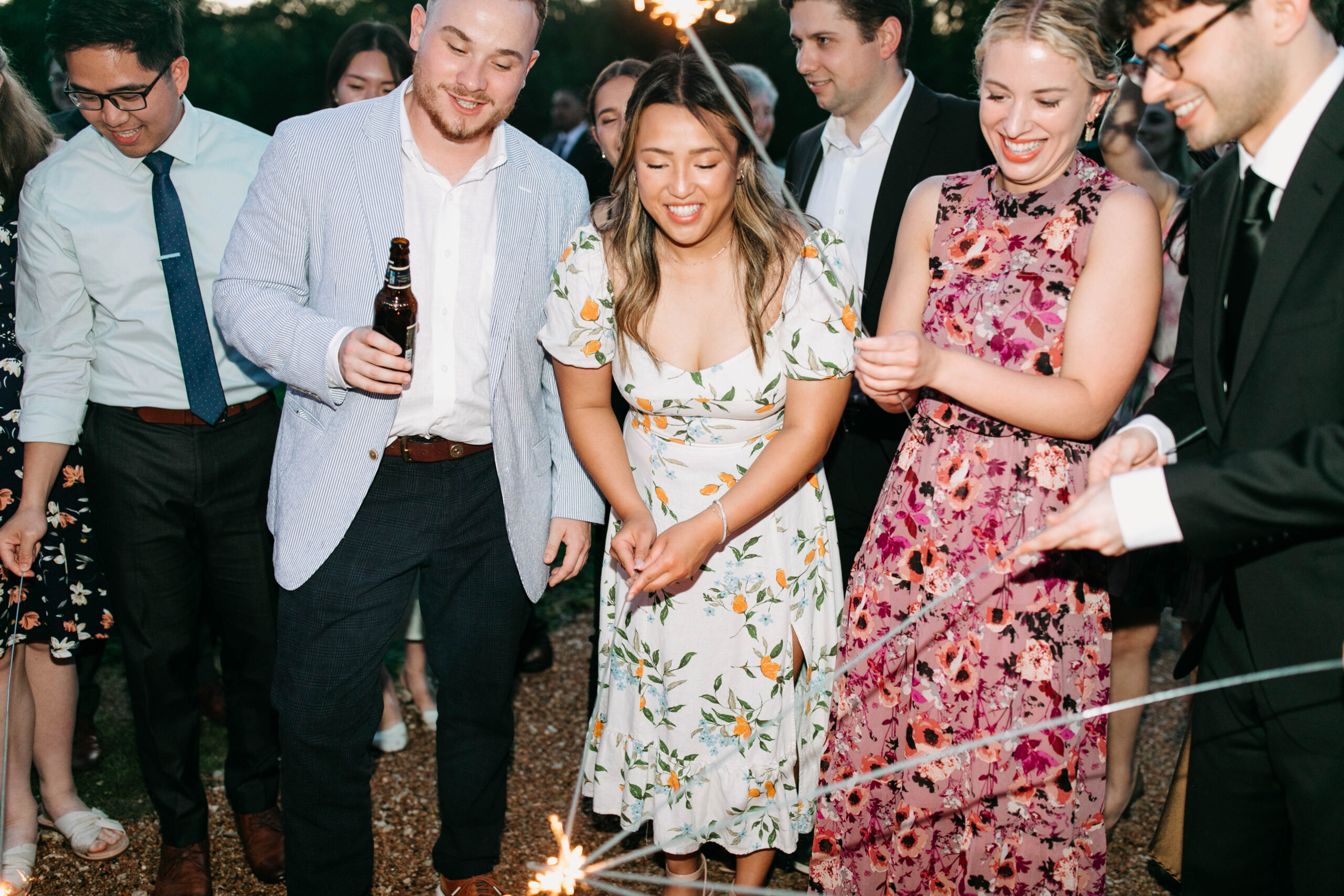 Photographs of wedding guests lighting sparklers to prepare for a reception exit. 