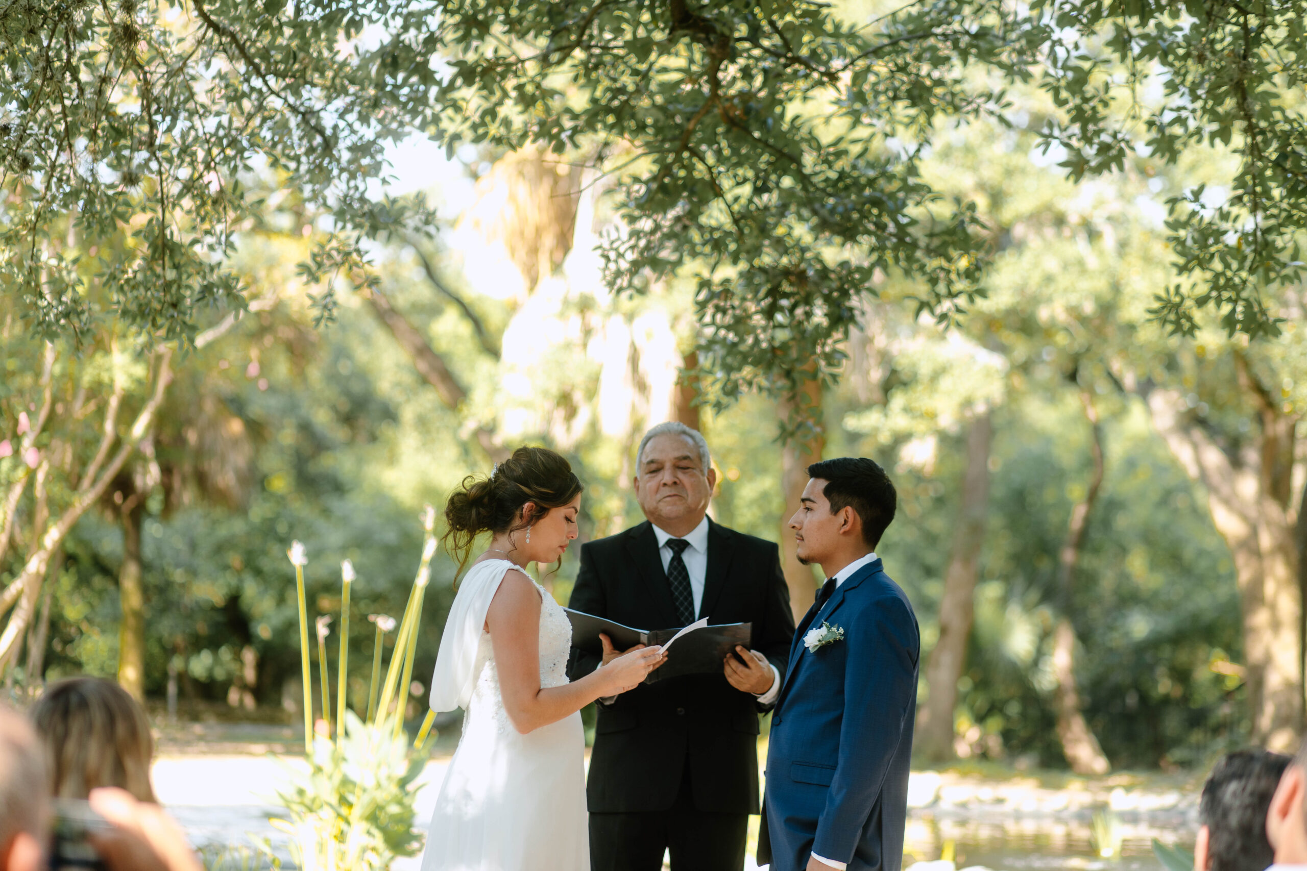 Couple exchanging vows with Ceremony Wedding Photography at Mayfield Gardens. Photograph by Bare Moments Photography. Taken during the summer in Austin, Texas. 