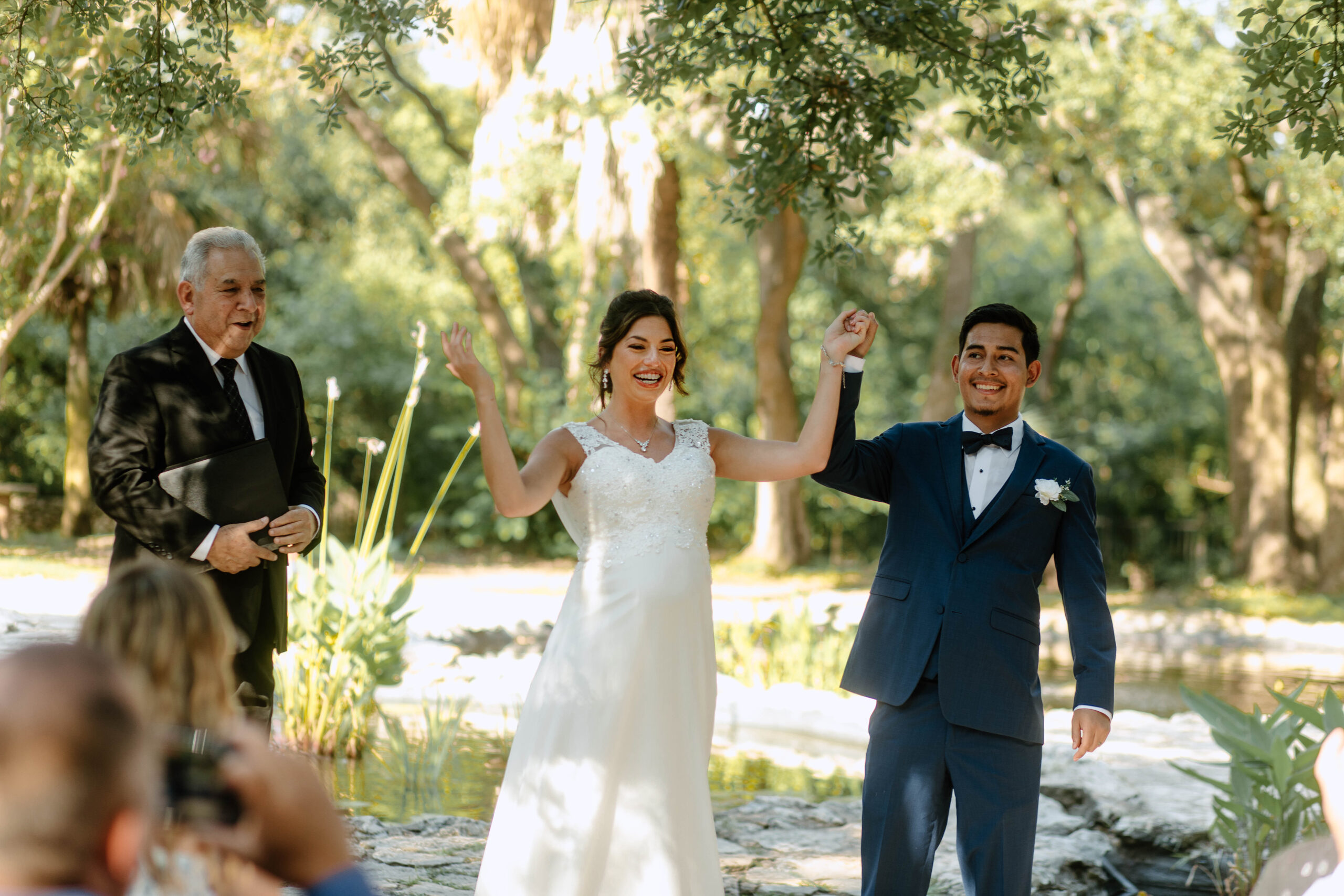 Wedding ceremony photography at a Mayfield Garden wedding in Austin Texas. Couple is cheering because they just got married. 