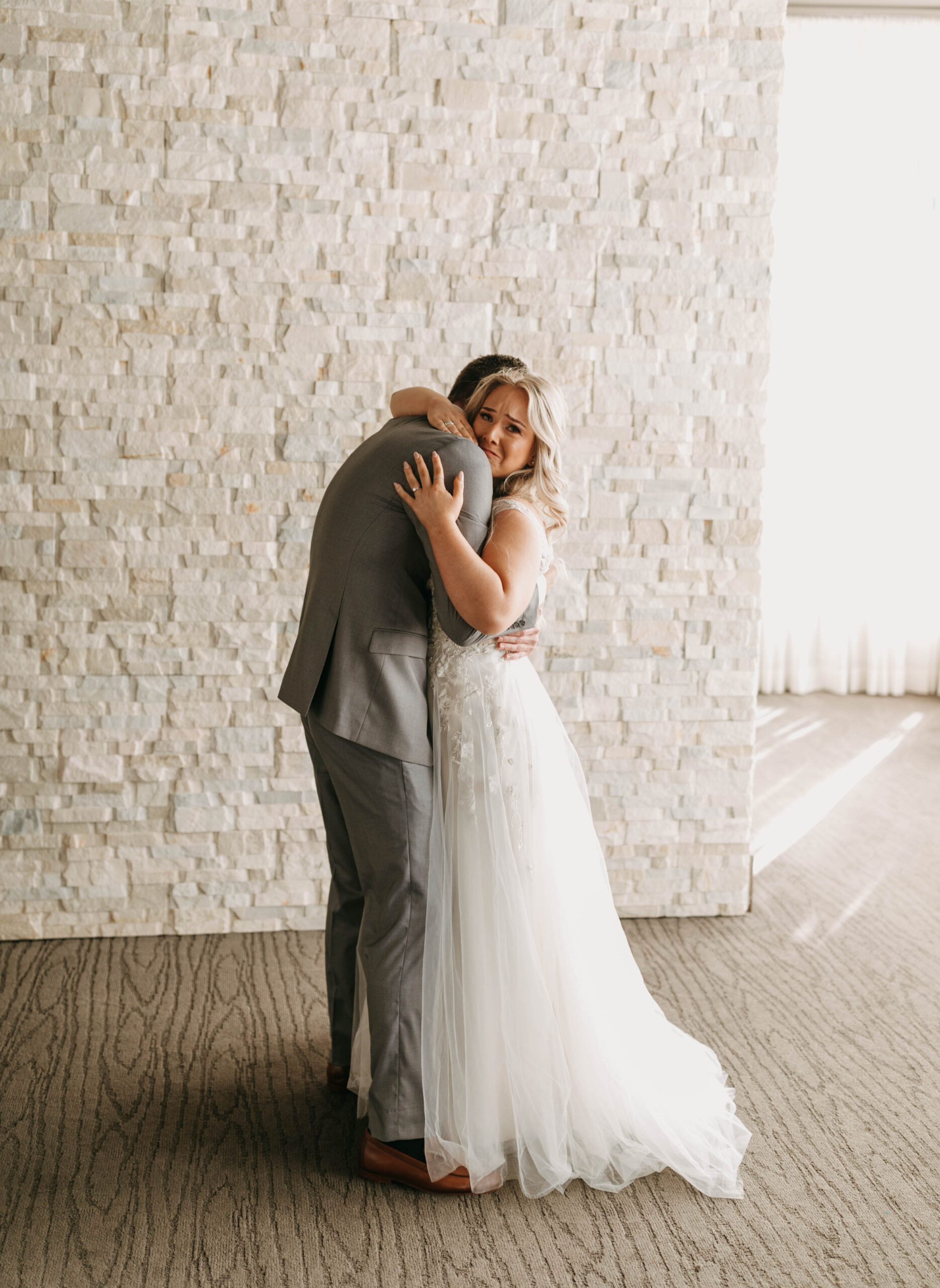 Couple crying and hugging on their wedding day. Emotional wedding photographs.