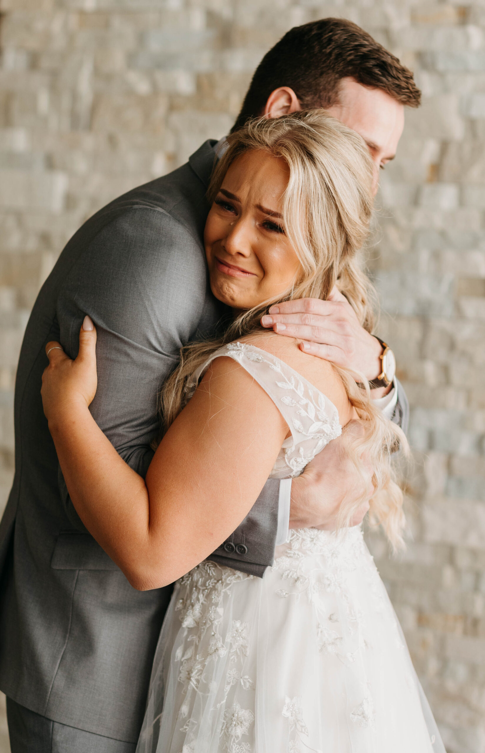 Couple crying and hugging on their wedding day. Emotional wedding photographs. 