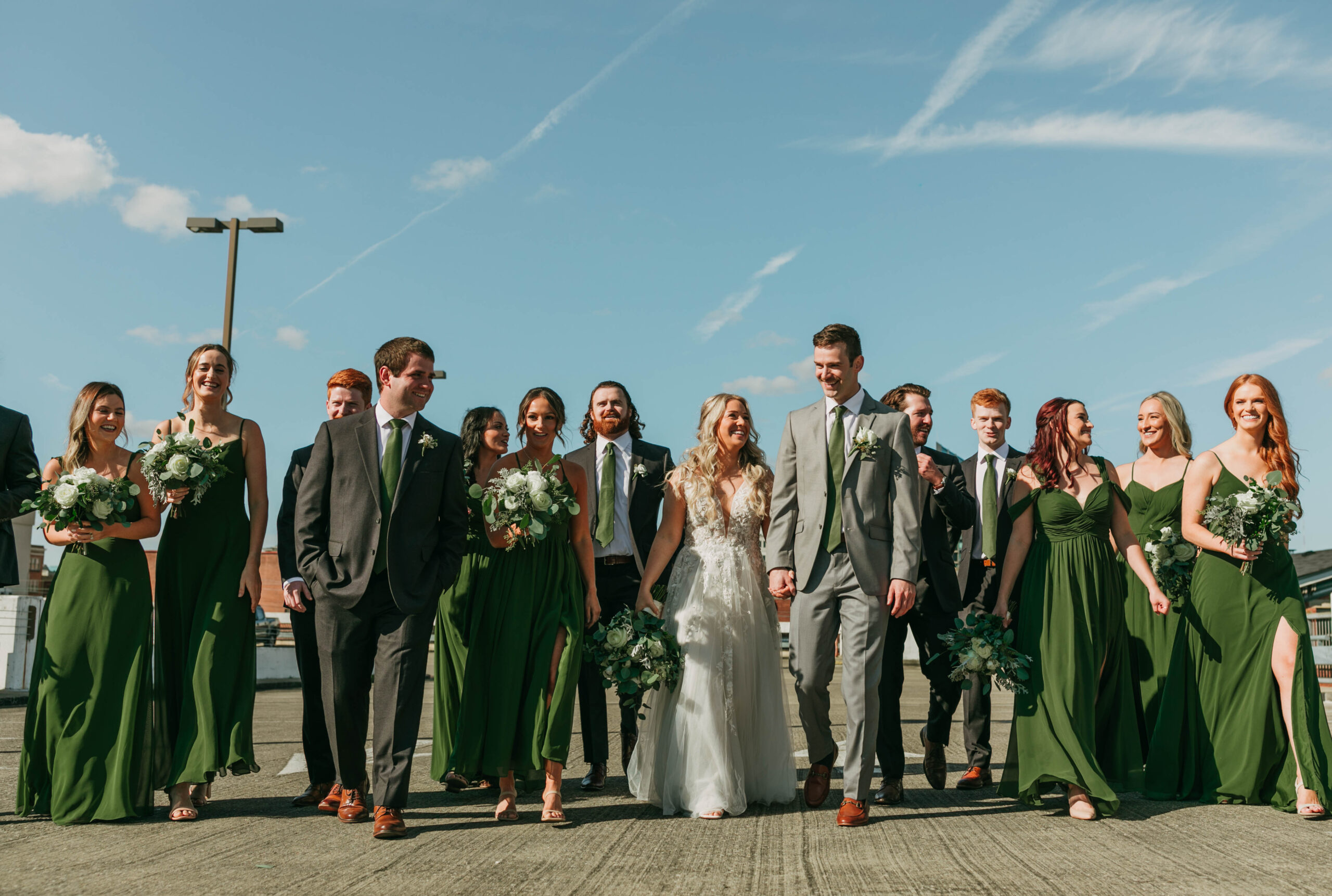 A full wedding party photograph with the city. 