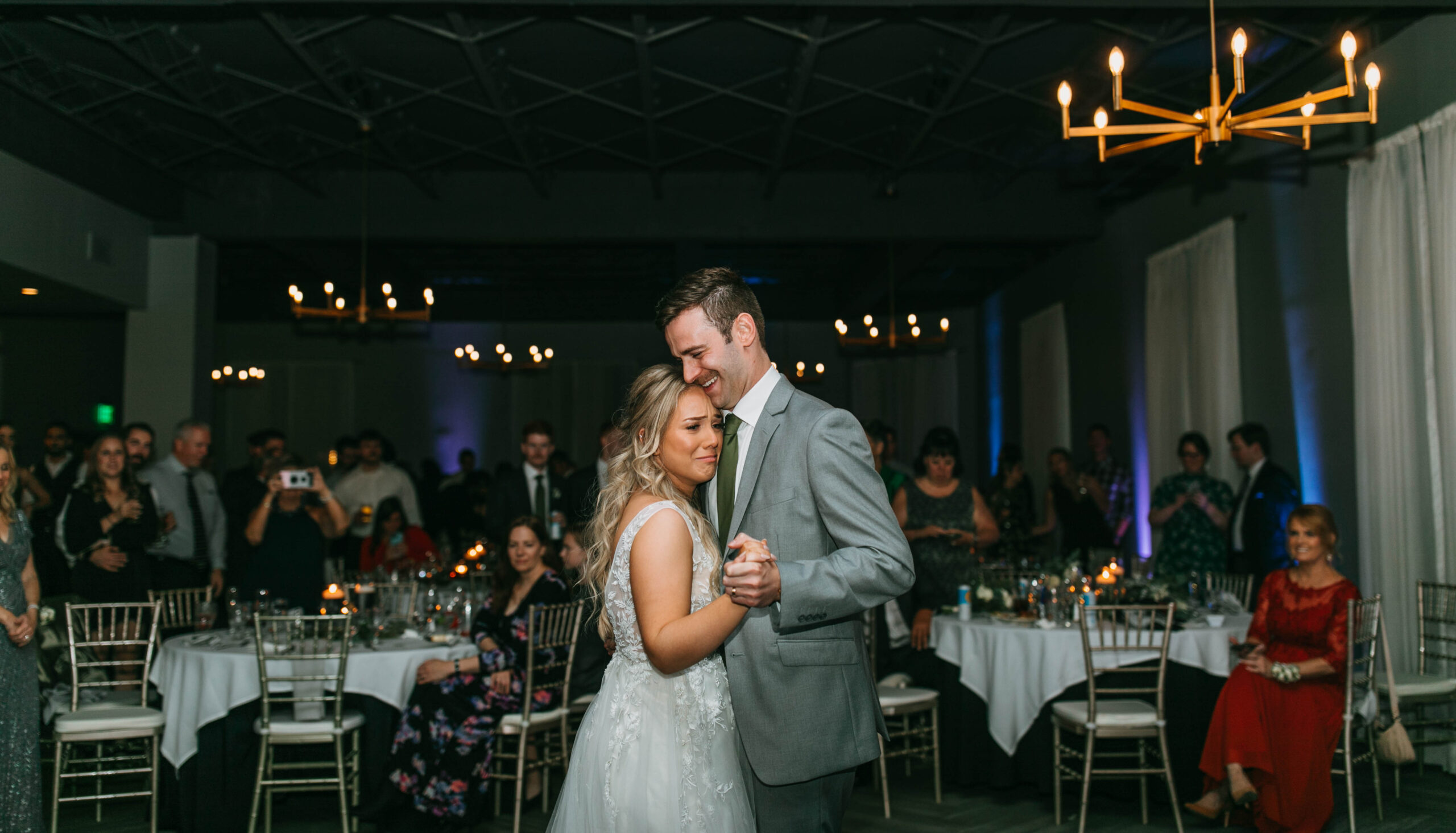 Candid wedding photograph of a couple dancing during their first dance at their hotel wedding reception.