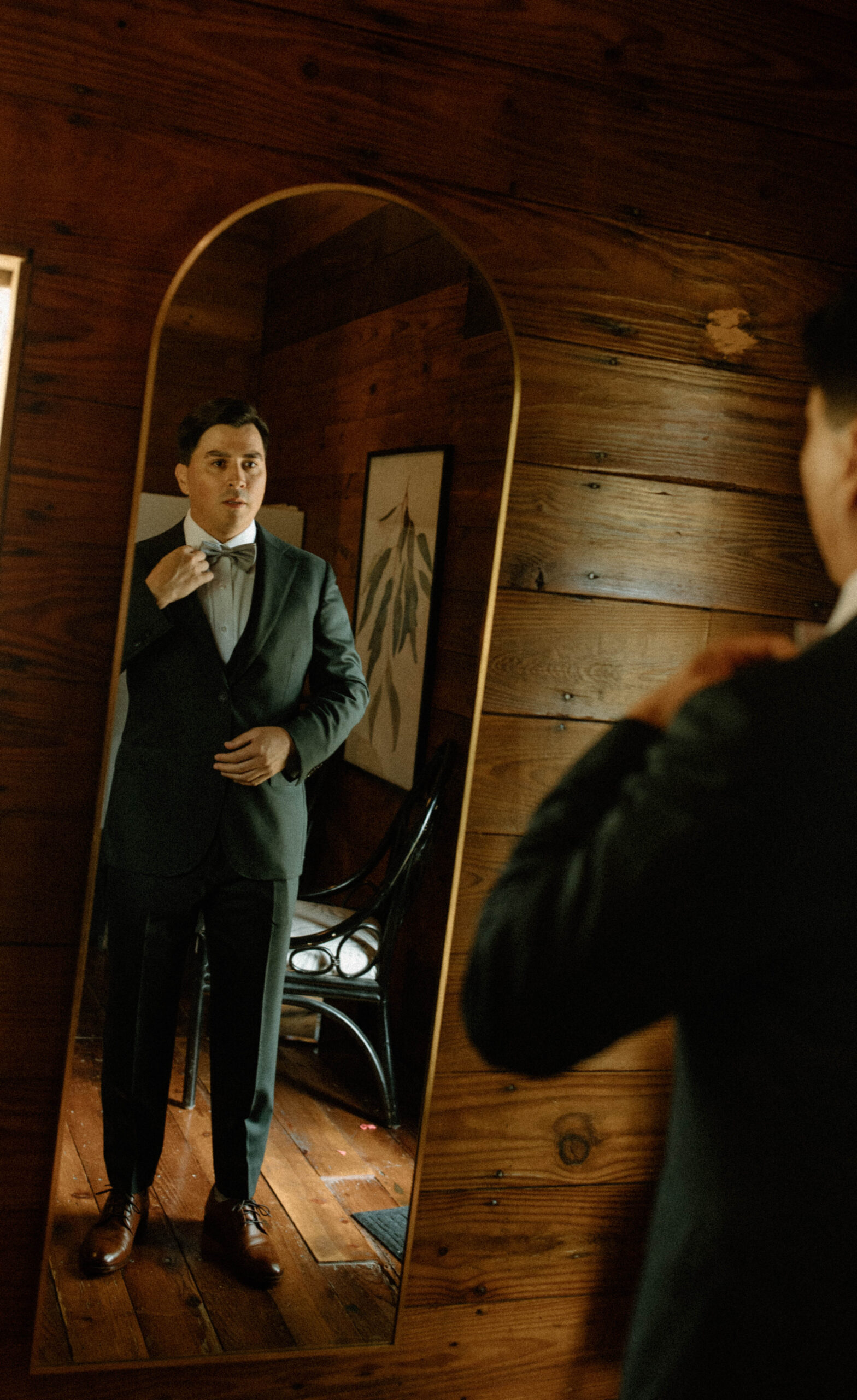 Wedding photograph of a groom putting on his suit on his wedding day. 