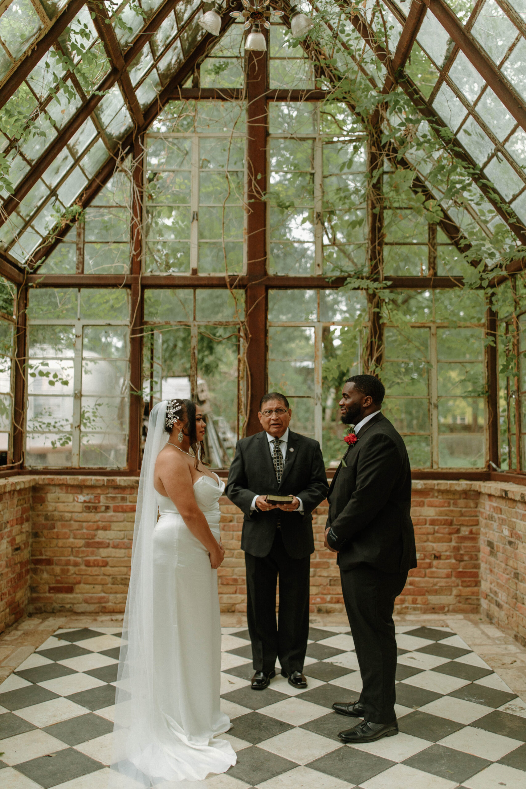 a wedding ceremony happening inside the greenhouse at Sekrit Theater in Austin Texas. 