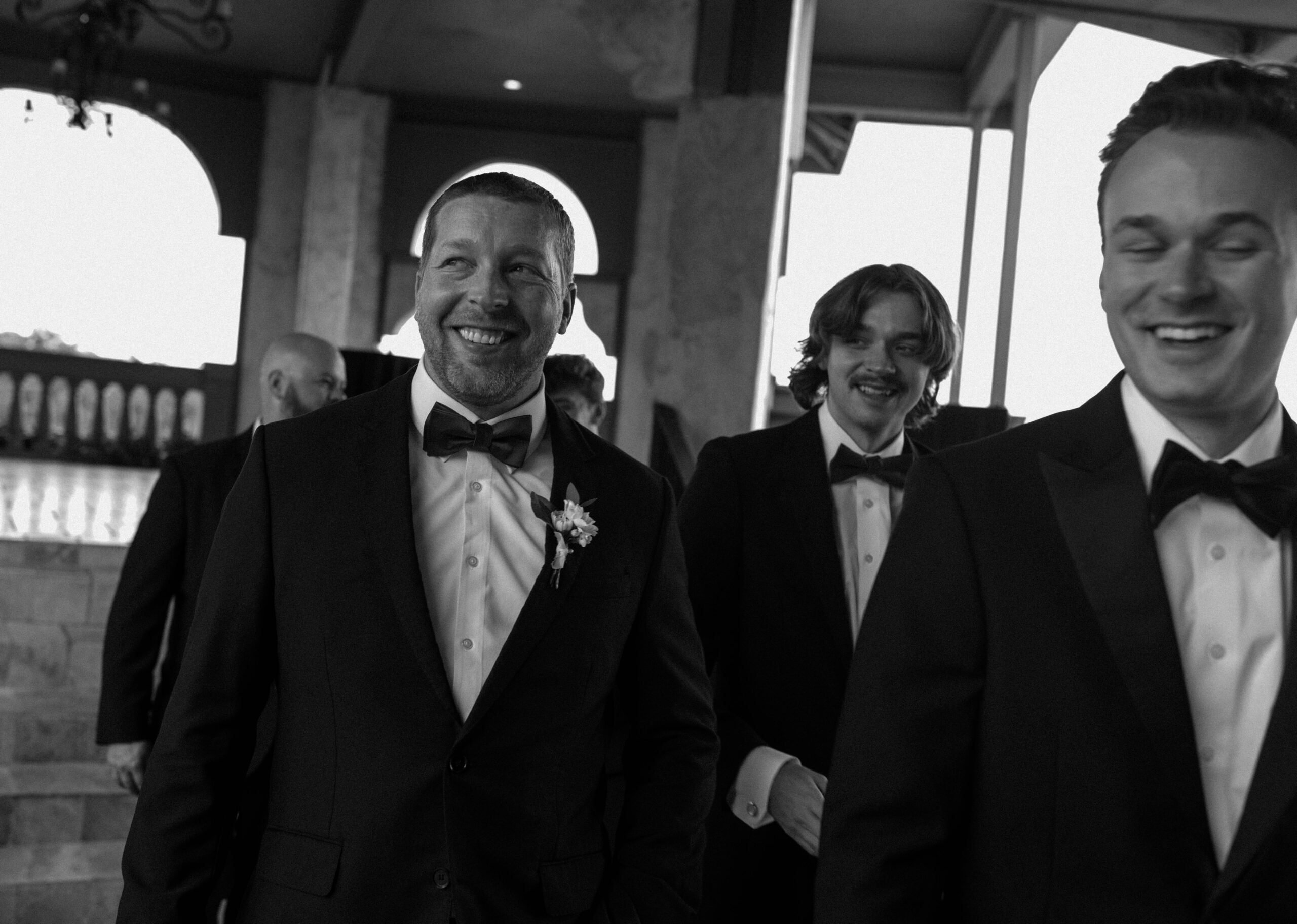 Candid black and white documentary Austin wedding photography shot of groomsmen walking.