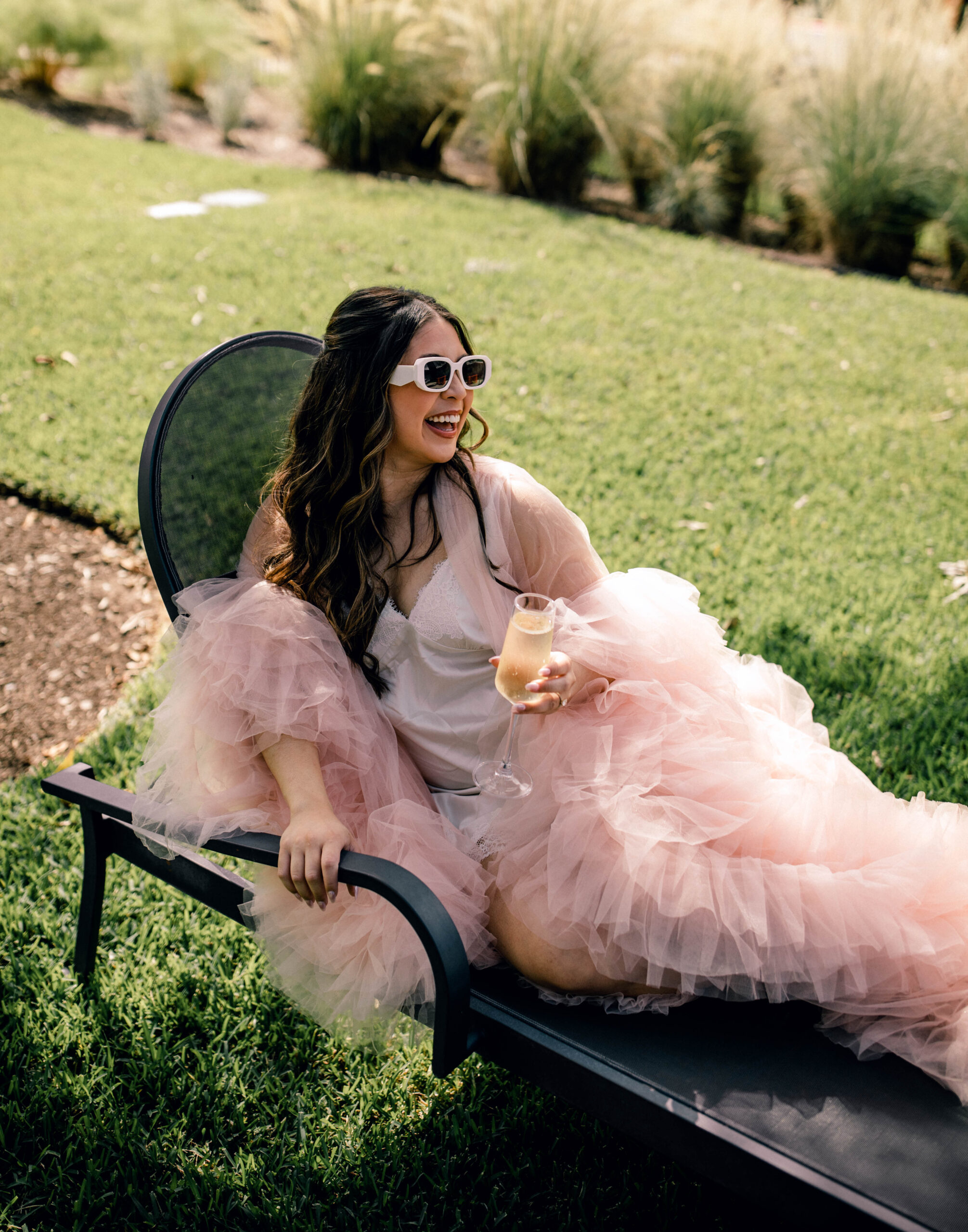 Poolside bridal photos in pink fluffy robe outside 