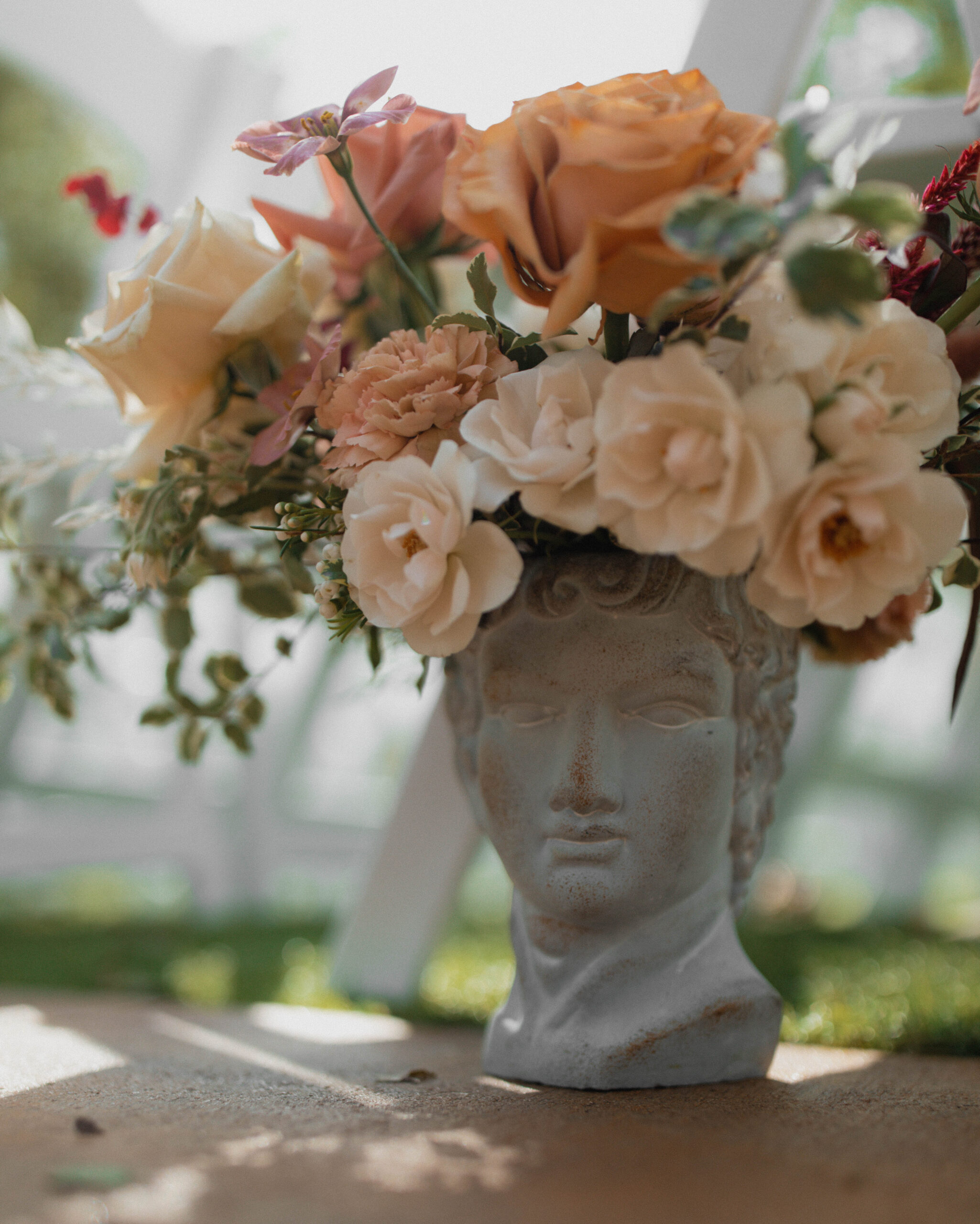 Close-up of sculpture vases adorned with elegant fall florals, adding sophistication to the wedding decor at Casa Blanca on Brushy Creek.