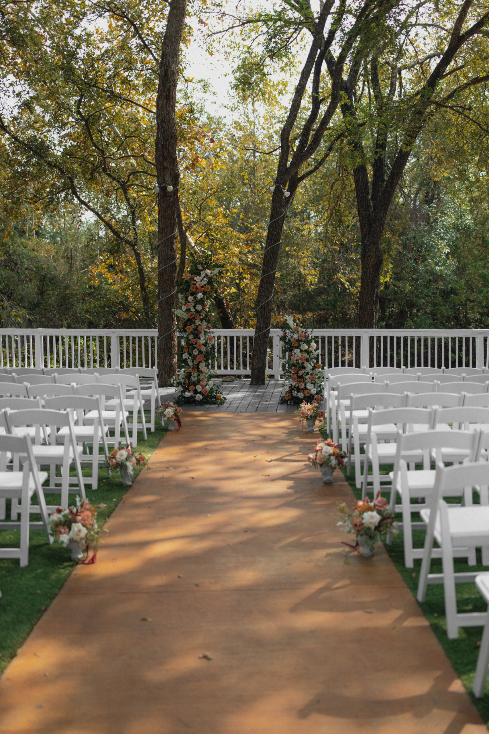 Breathtaking riverside garden ceremony at Casa Blanca Wedding in Austin, Texas, with autumnal foliage and elegant floral arrangements.