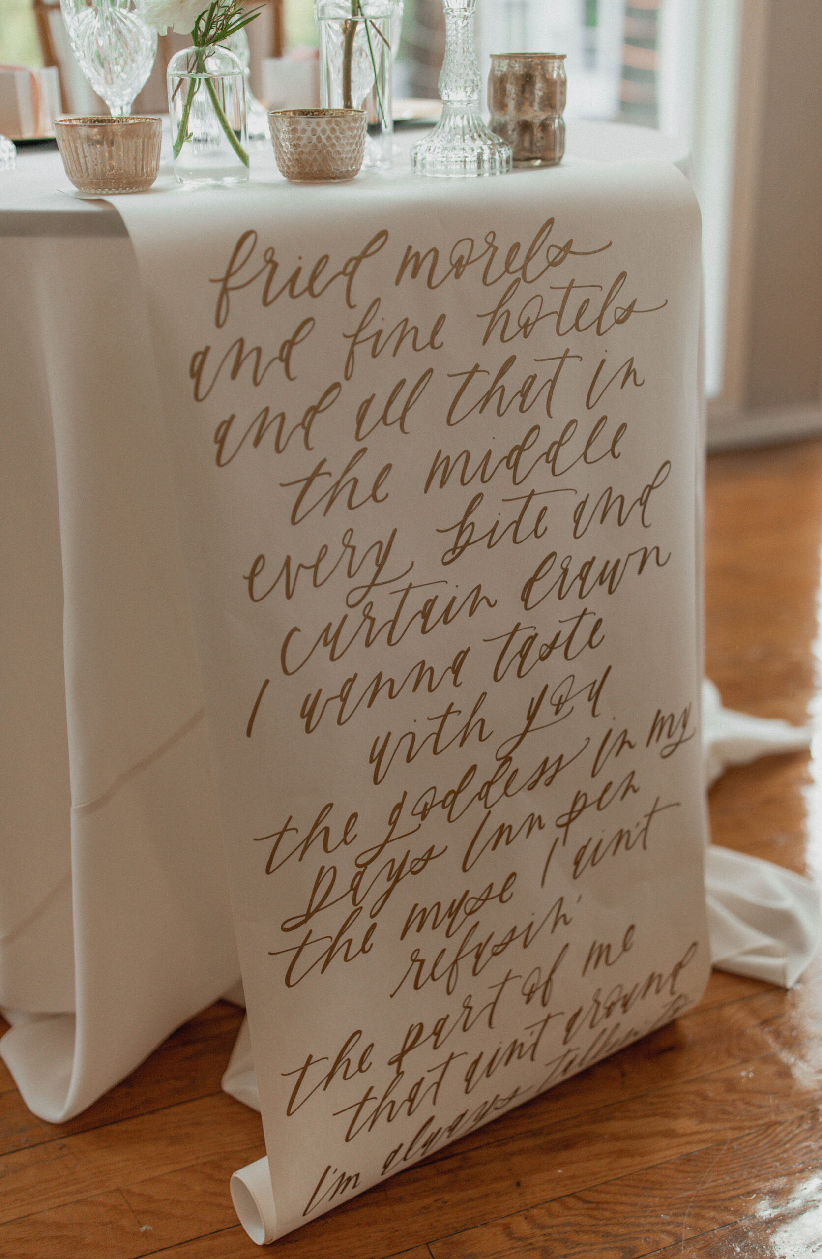 Hand written love quote table scroll at a sweetheart table during wedding reception. 